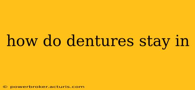 how do dentures stay in